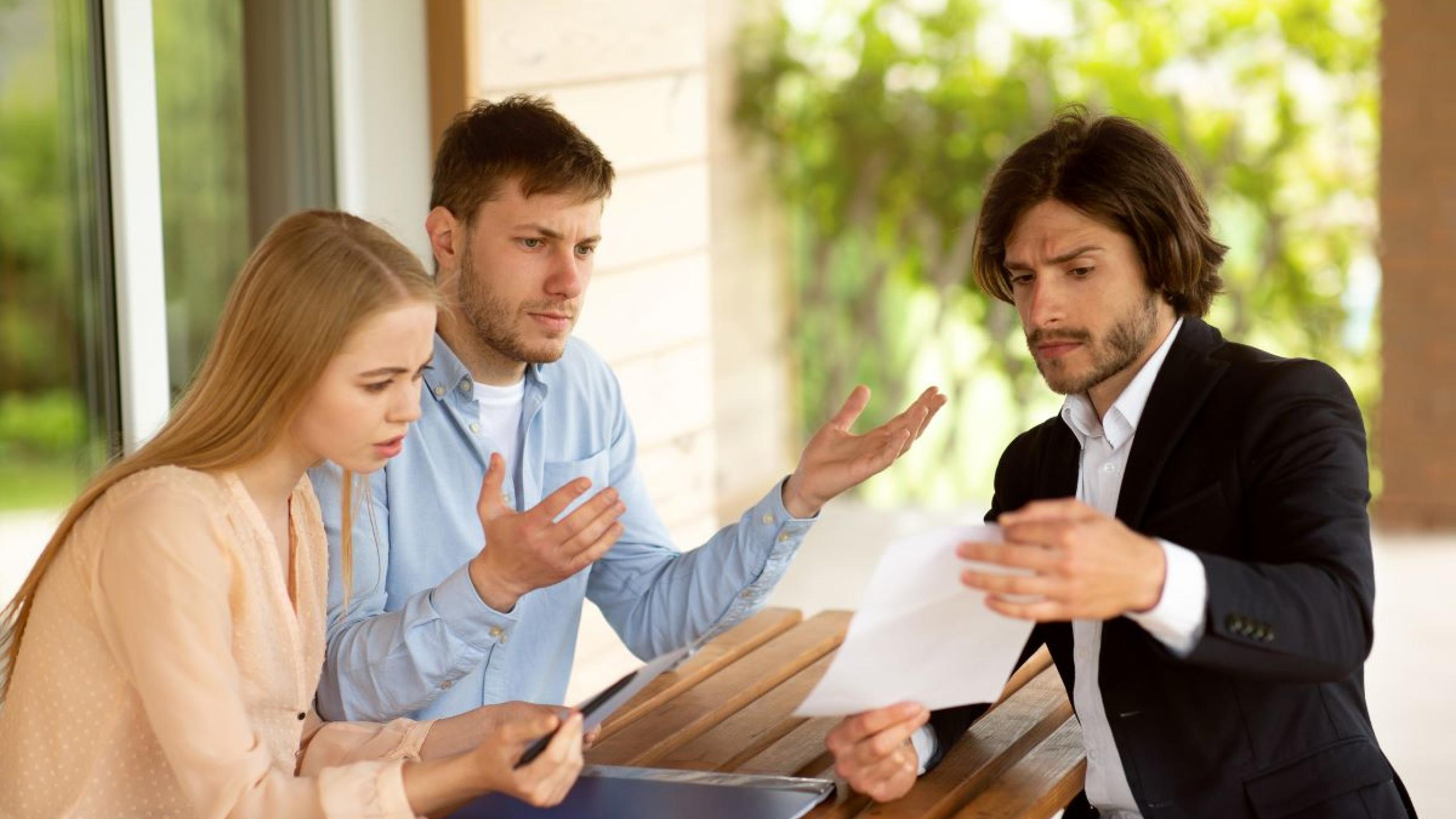 Man en vrouw hebben discussie met verkoper.