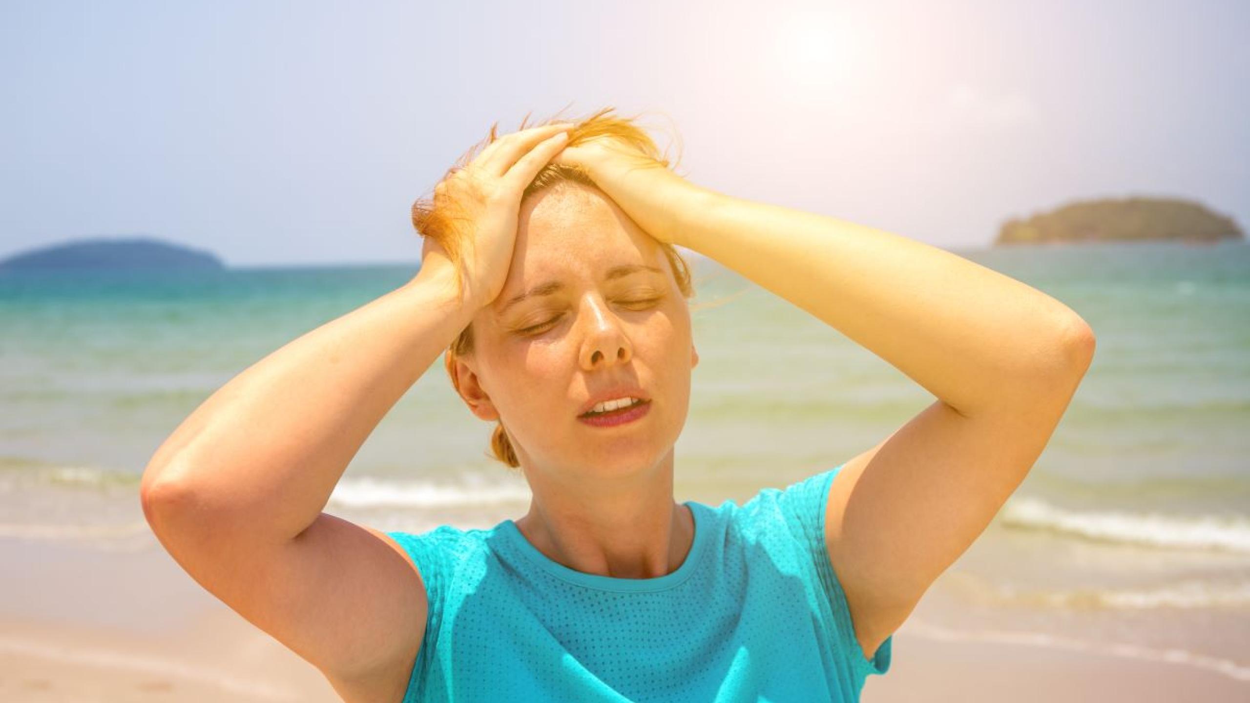 Vrouw op het strand met hoofdpijn