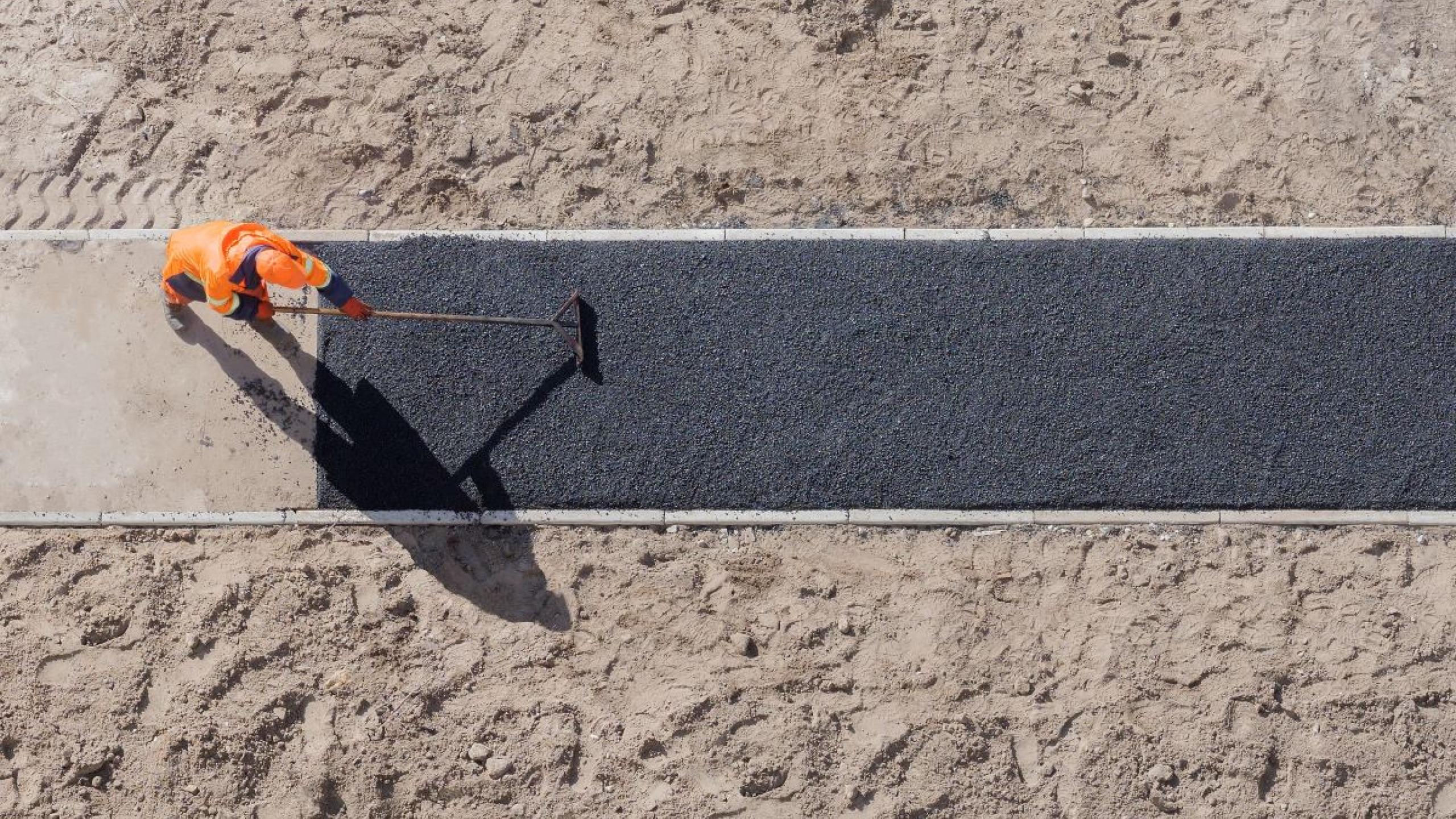 Dronebeeld man werkt aan nieuw fietspad.