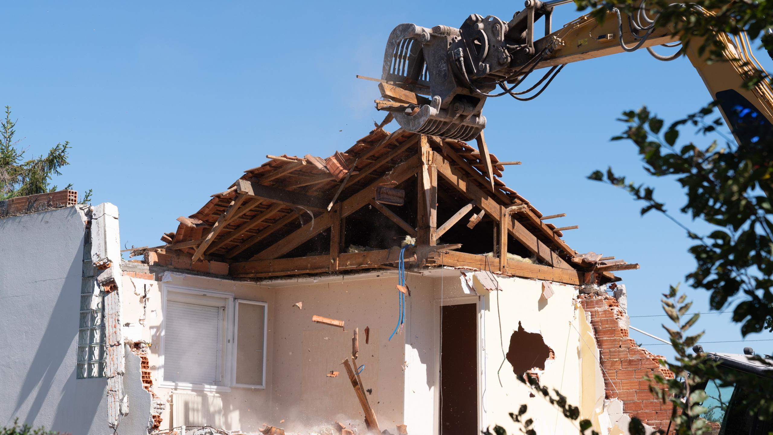 excavator in demolition of home residential building